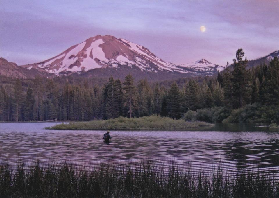 Sunset bathes Lassen Peak and Manzanita Lake in cool hues at Lassen Volcanic National Park.