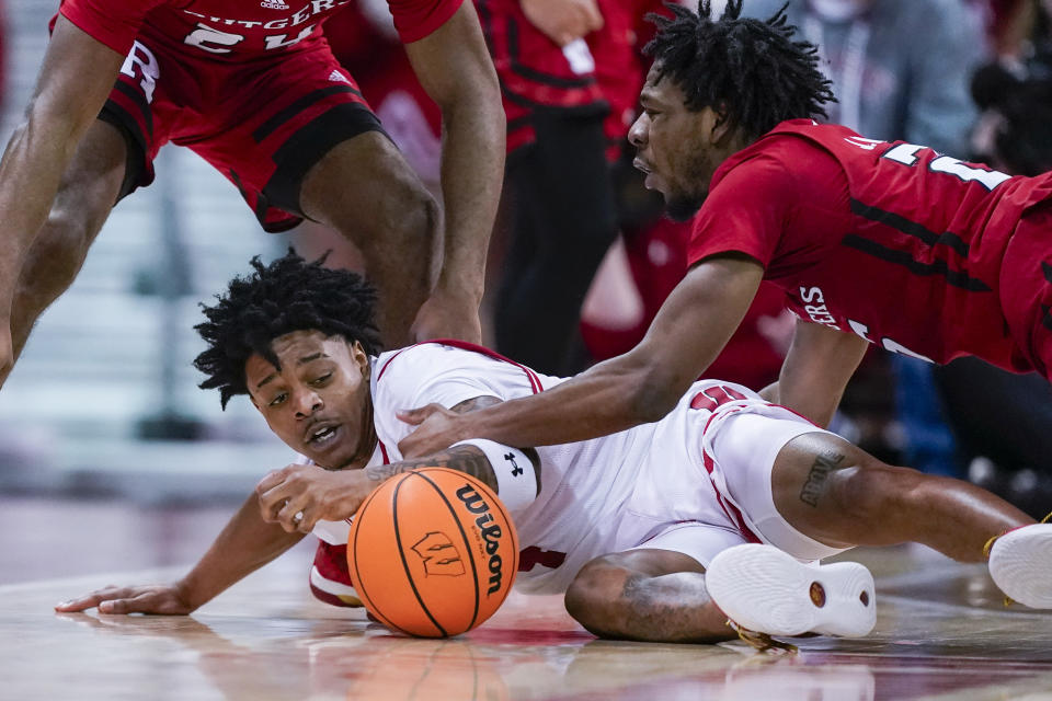 Wisconsin's Kamari McGee (4) and Rutgers' Jeremiah Williams, right, scramble for the ball during the second half of an NCAA college basketball game Thursday, March 7, 2024, in Madison, Wis. (AP Photo/Andy Manis)