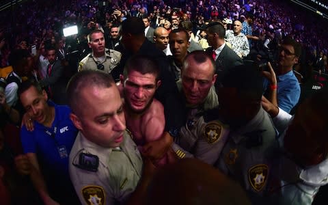 Khabib Nurmagomedov of Russia is escorted out of the arena - Credit: Harry How/Getty Images