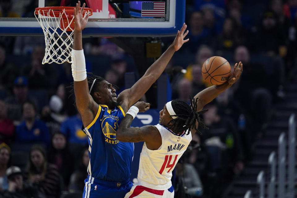 Los Angeles Clippers guard Terance Mann, right, tries to shoot while defended by Golden State Warriors center Kevon Looney during the first half of an NBA basketball game Thursday, Nov. 30, 2023, in San Francisco. (AP Photo/Godofredo A. Vásquez)