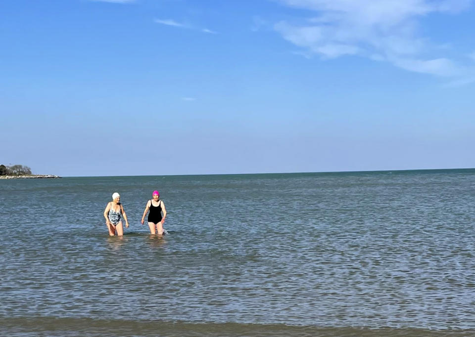 Roberta Rubin, 85, left, and Dorothy Harza, 93, wade in the water after a late-autumn swim in Lake Michigan on Nov. 10, 2022, in Evanston, Ill. Harza swims nearly daily in Lake Michigan from May to November. (Roberta Rubin via AP)