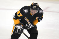 Pittsburgh Penguins' Sidney Crosby grimaces after being hit in the left arm while taking a face-off during the period of an NHL hockey game against the Anaheim Ducks in Pittsburgh, Saturday, Dec. 11, 2021.(AP Photo/Gene J. Puskar)