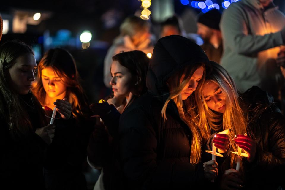 People stand with lit candles during a candlelight vigil at Children's Park in Lake Orion on Thursday, Dec. 2, 2021, while showing support for neighboring village of Oxford after an active shooter situation at Oxford High School that left four students dead and multiple others with injuries.