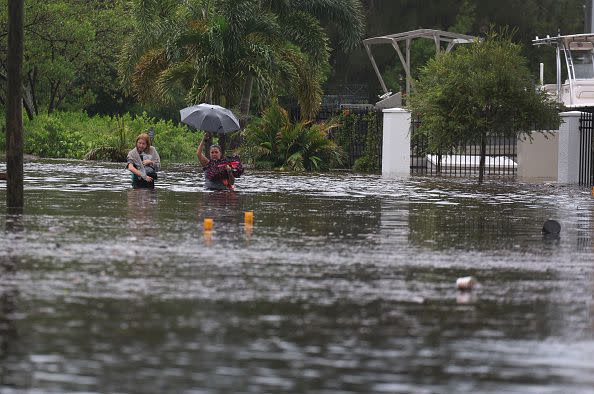 TARPON SPRINGS, FLORIDA - AUGUST 30: Makatla Ritchter (L) and her mother, Keiphra Line wade through flood waters after having to evacuate their home when the flood waters from Hurricane Idalia inundated it on August 30, 2023 in Tarpon Springs, Florida. Hurricane Idalia is hitting the Big Bend area of Florida. (Photo by Joe Raedle/Getty Images)