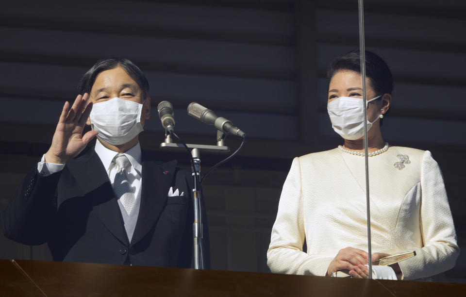 Japan's Emperor Naruhito and Empress Masako wave to well-wishers through a bullet-proof glass from a balcony during their New Year's public appearance at the Imperial Palace in Tokyo Monday, Jan. 2, 2023. The annual celebration returned after a two-year hiatus for coronavirus restrictions. (Franck Robichon/Pool Photo via AP)