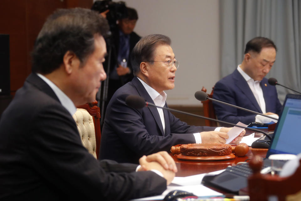 South Korean President Moon Jae-in, center, speaks during an emergency cabinet meeting at the presidential Blue House in Seoul, South Korea, Friday, Aug. 2, 2019. Moon has vowed stern countermeasures against Japan's decision to downgrade its trade status, which he described as a deliberate attempt to contain South Korea's economic growth and a "selfish" act that would damage global supply chains. (Bae Jae-man/Yonhap via AP)