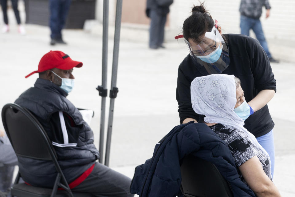 A doctor, from Michael Garron Hospital, administers a Moderna Covid-19 vaccine during the coronavirus pandemic at a mobile vaccination site outside the Masjid Mosque in Toronto, Friday, April 9, 2021. (Chris Young/The Canadian Press via AP)