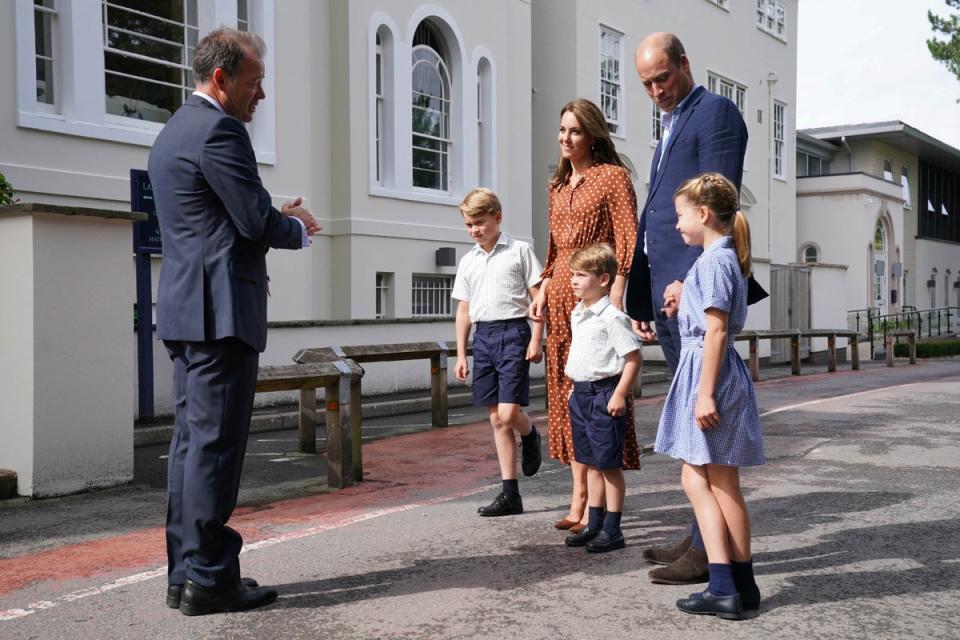 Prince George, Princess Charlotte and Prince Louis, accompanied by their parents Prince William and Catherine, Duchess of Cambridge, are greeted by Headmaster Jonathan Perry (REUTERS)