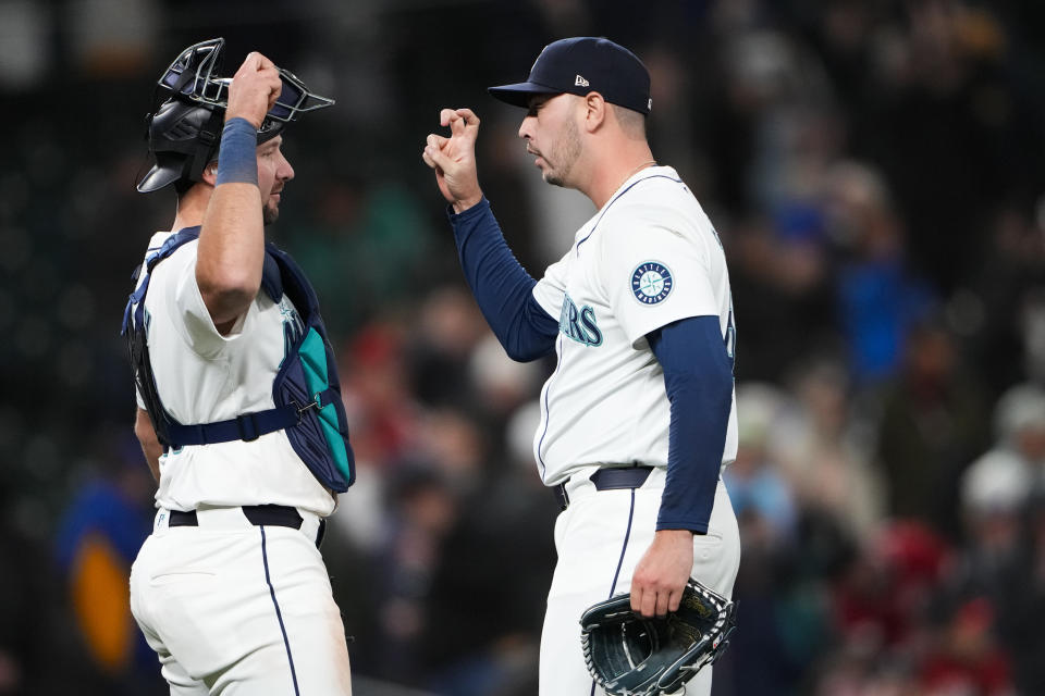 Seattle Mariners catcher Cal Raleigh, left, greets relief pitcher Tayler Saucedo after the team's win over the Cincinnati Reds in a baseball game Tuesday, April 16, 2024, in Seattle. (AP Photo/Lindsey Wasson)