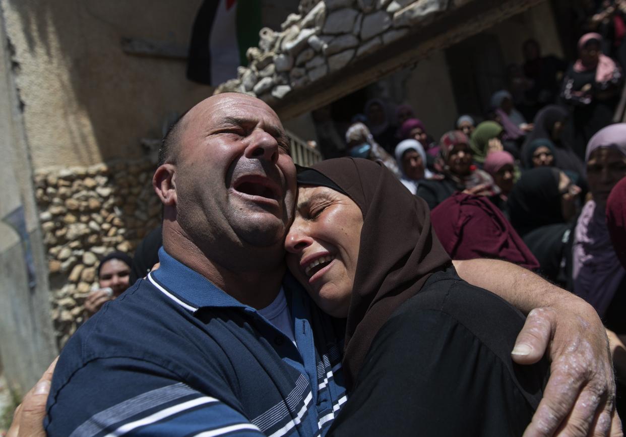 Palestinian mourners cry while taking a last look at the body of Mohammad Daraghmeh at the family house during his funeral in the West Bank village of Lubban, near Nablus, Wednesday, May 12, 2021. Israeli soldiers opened fire yesterday at a Palestinian vehicle at an army checkpoint north of the West Bank, killing Daraghmeh, a passenger, and critically wounding another, the Palestinian health ministry said.