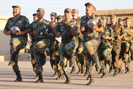 New Syrian army recruits carry their plates as they march before heading for their Iftar (breaking fast) meals at a military training camp in Damascus, Syria June 26, 2016. REUTERS/Omar Sanadiki/File Photo