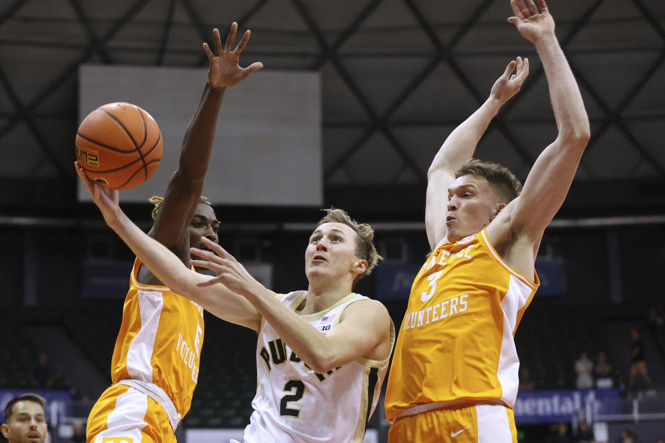 Purdue guard Fletcher Loyer (2) goes to the net between Tennessee guard Jahmai Mashack and guard Dalton Knecht (3) during the first half of an NCAA college basketball game Tuesday, Nov. 21, 2023, in Honolulu. (AP Photo/Marco Garcia)