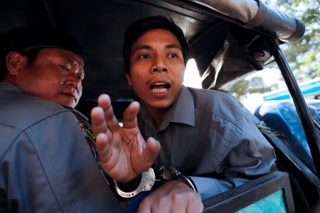 Detained Reuters journalist Kyaw Soe Oo shouts to media, after a court hearing in Yangon, Myanmar February 1, 2018. REUTERS/Jorge Silva