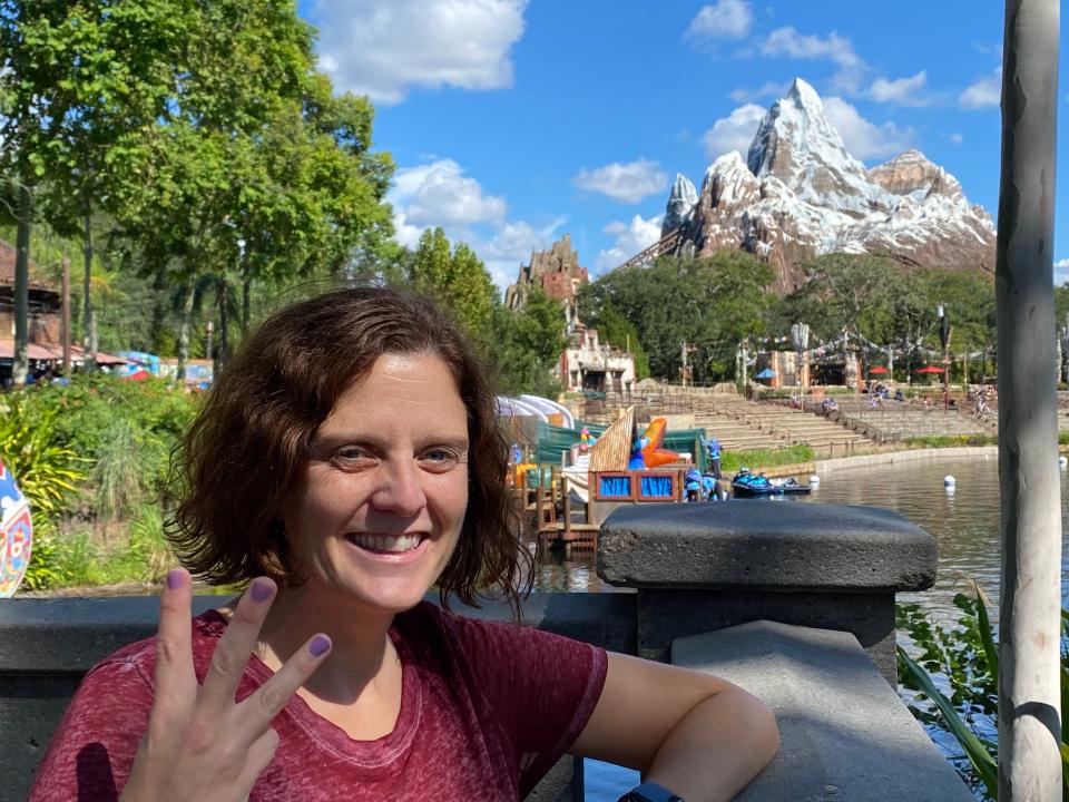 kari posing in front of expedition evrest mountain holding up three fingers
