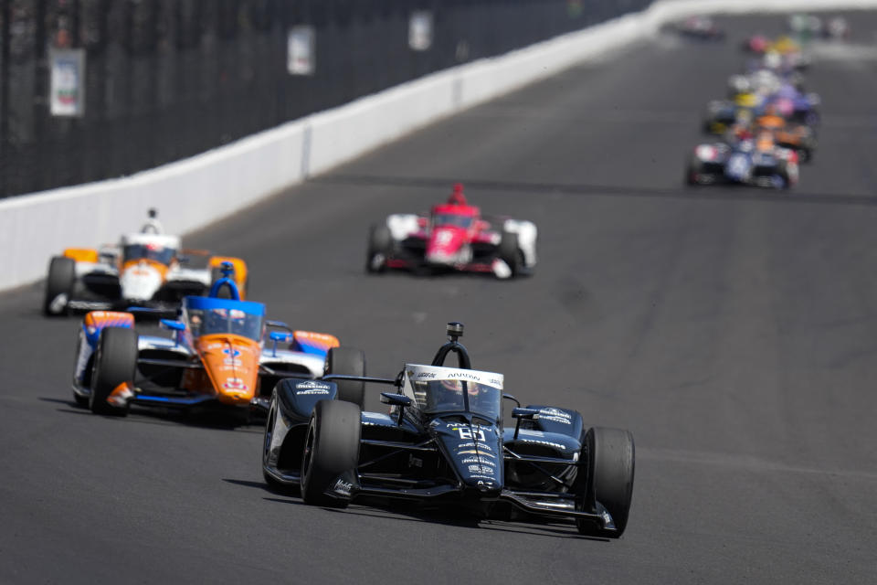 Pato O'Ward, of Mexico, leads a pack as they head into the first turn during the final practice for the Indianapolis 500 auto race at Indianapolis Motor Speedway in Indianapolis, Friday, May 26, 2023. (AP Photo/Michael Conroy)