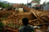 A villager stands near damaged houses after a landslide hit Pasir Panjang village in Brebes, Indonesia, February 23, 2018. Antara Foto/Oky Lukmansyah/ via REUTERS