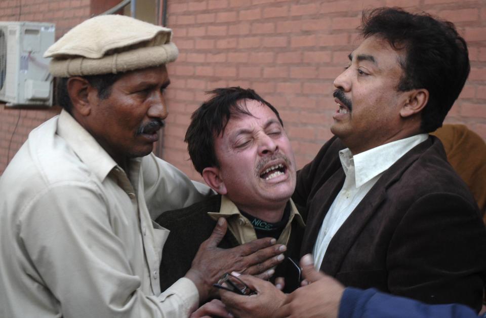 A man cries over the death of his relative, who was killed in an explosion in a Shi'ite mosque, outside a hospital in Peshawar