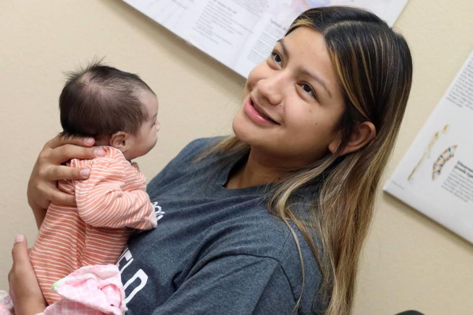 Sofia Lira listens to pediatrician Dr. Rodrigo De La Cruz's instructions during a checkup on the baby at the Altura Centers for Health clinic in West Tulare on Sept. 7, 2023.