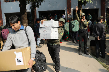 Law enforcement officials carry electronic voting materials as they distribute them to different voting centre ahead of 11th general election which will be held on December 30 in Dhaka, Bangladesh, December 29, 2018. REUTERS/Mohammad Ponir Hossain