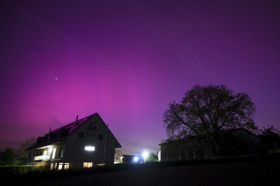 Northern lights glow in the night sky above the village of Daillens, Switzerland, early Saturday, May 11, 2024. (Laurent Gillieron/Keystone via AP)