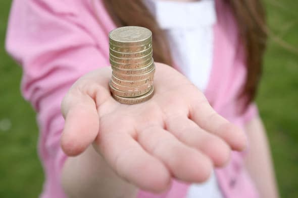 girl holding pound coins