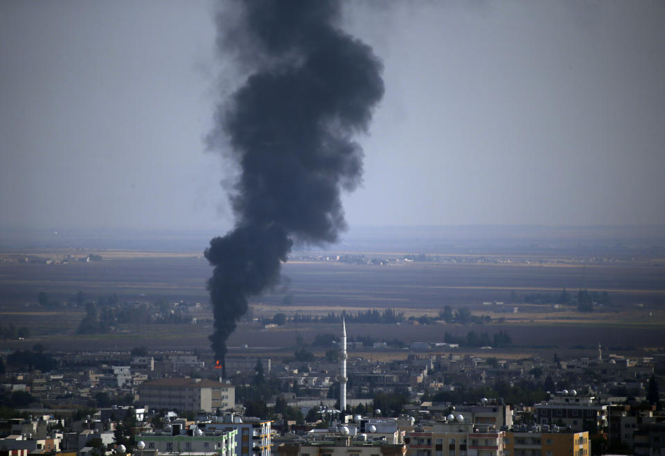 In this photo taken from the Turkish side of the border between Turkey and Syria, in Ceylanpinar, Sanliurfa province, southeastern Turkey, smoke billows from a fire in Ras al-Ayn, Syria, Friday, Oct. 18, 2019. Fighting broke out in the morning hours in the Syrian border town which has been a flashpoint in the fight between Turkey and Kurdish forces despite a U.S.-brokered cease-fire that went into effect overnight. The fighting died down in mid-morning. (AP Photo/Lefteris Pitarakis)