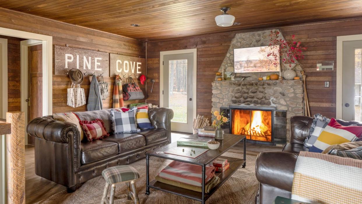 a cabin with a leather sofa and a stone fireplace