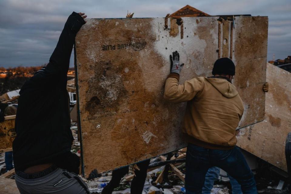 Residents and visitors work to clear debris in search of pets and belongings of a destroyed home in the aftermath of a tornado on Dec. 10, 2023, in Clarksville, Tennessee.