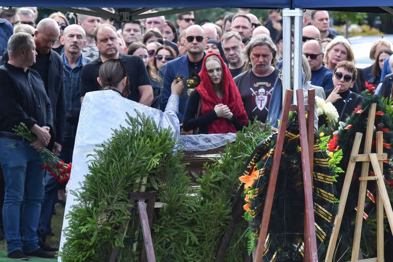 Un sacerdote ortodoxo dirige un funeral ante el ataúd de Valery Chekalov