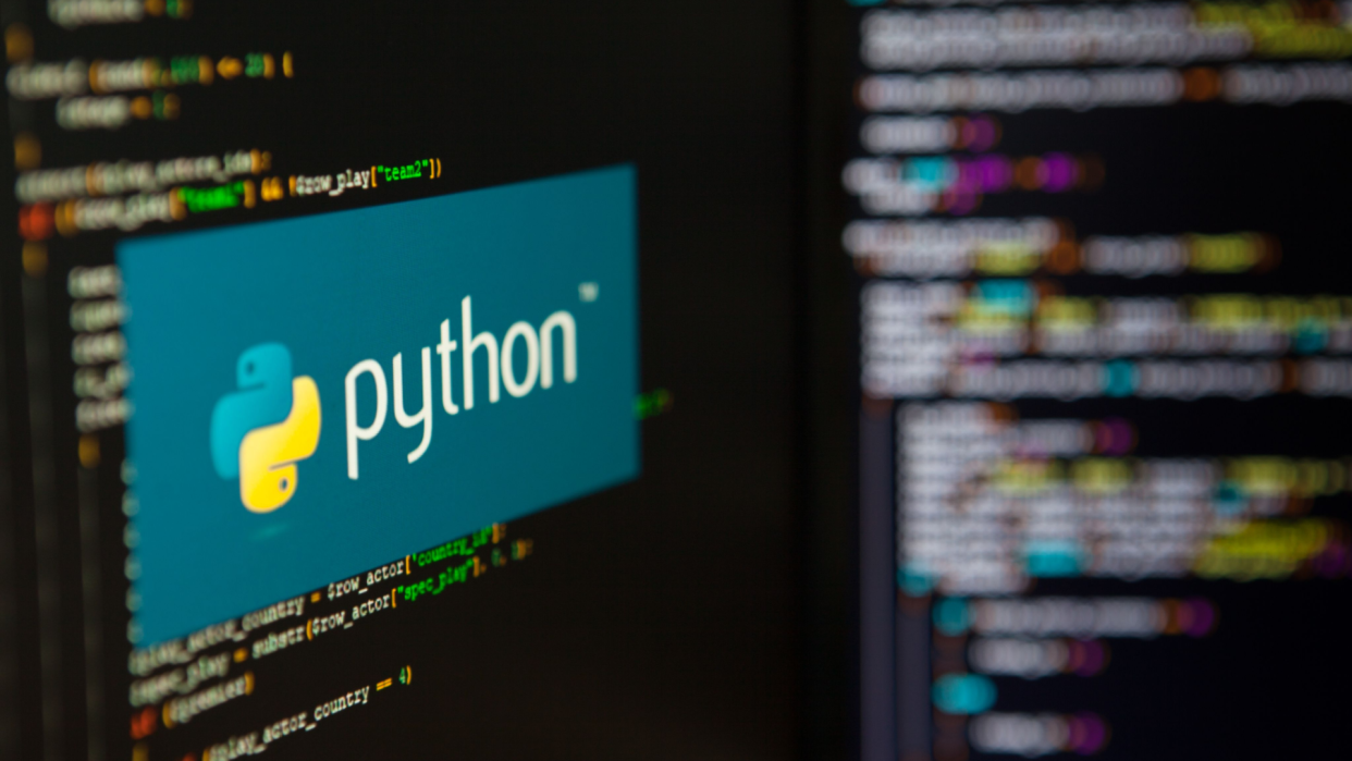  The Python banner logo on a computer screen running a code editor. 