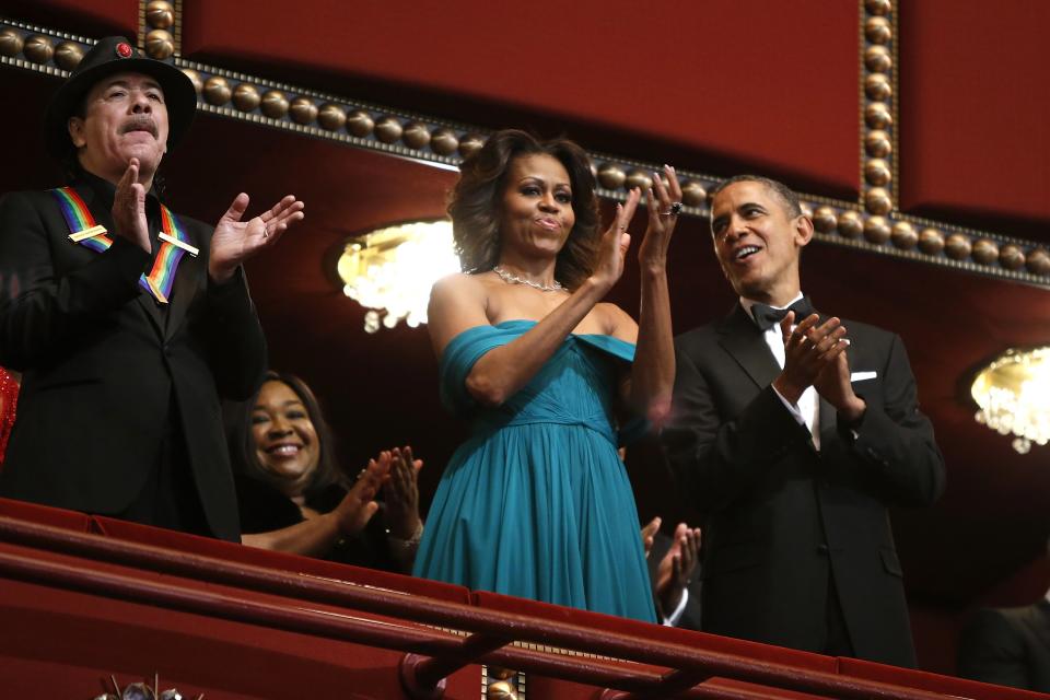 U.S. President Barack Obama, first lady Michelle Obama and Carlos Santana applaud in their box during the Kennedy Center Honors in Washington