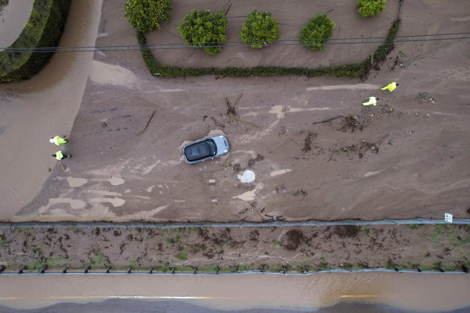 A vehicle is trapped by mud and debris at Jameson Lane near Highway 101 in Montecito, Calif., Tuesday, Jan. 10, 2023. The series of storms that have struck California have poured water on a state mired in a years-long drought. Experts say the precipitation will help relieve the drought somewhat. (AP Photo/Ringo H.W. Chiu)