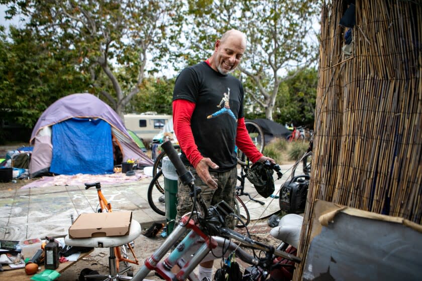 VENICE, CA - MAY 23: David Minasian stands at his tent at homeless encampment outside Abbot Kinney Memorial Branch Library on Monday, May 23, 2022 in Venice, CA. Minasian has lived at the encampment for five months and where he works on bikes for extra cash. Minasian said he is currently searching for permanent housing but is not having any luck. (Jason Armond / Los Angeles Times)