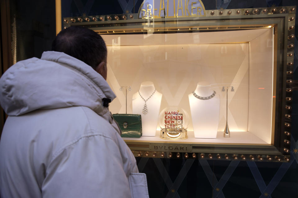 A man looks at a Bulgari fashion shop window, in the Montenapoleone shopping district, in Milan, Italy, Tuesday, Feb. 4, 2020. China's virus outbreak is giving global business a chill. In Milan’s luxury Montenapoleone shopping district, dozens of luxury brands decked out their windows for Chinese New Year. But wealthy Chinese shoppers, who are responsible for about one-third of all luxury purchases globally, have failed to arrive in their usual numbers. (AP Photo/Luca Bruno)