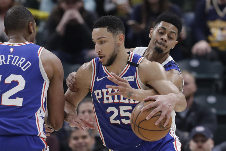 Philadelphia 76ers' Ben Simmons (25) is defended by Indiana Pacers' Jeremy Lamb (26) during the first half of an NBA basketball game, Monday, Jan. 13, 2020, in Indianapolis. (AP Photo/Darron Cummings)