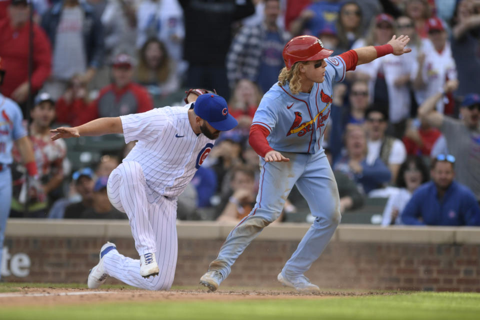 St. Louis Cardinals' Harrison Bader, right, reacts after scoring on a wild pitch while Chicago Cubs closing pitcher Tommy Nance, left, attempts to apply the tag during the ninth inning of a baseball game Saturday, Sept. 25, 2021, in Chicago. St. Louis won 8-5. (AP Photo/Paul Beaty)