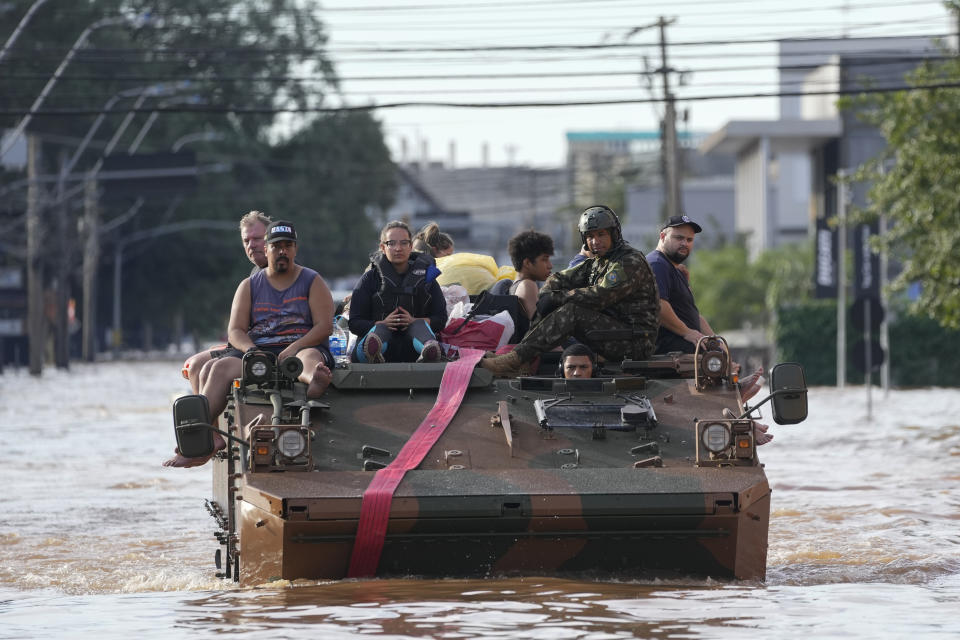 Residents are evacuated in a military vehicle from an area flooded by heavy rains, in Porto Alegre, Brazil, Tuesday, May 7, 2024. (AP Photo/Andre Penner)