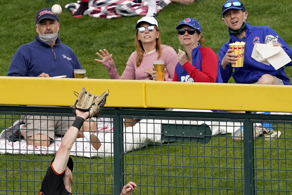 FILE - Fans watch as San Francisco Giants' Mike Yastrzemski catches a deep fly-out hit by Chicago Cubs' Joc Pederson during the third inning of a spring training baseball game, Friday, March 26, 2021, in Mesa, Ariz. Spring training games might not count in the official standings, but they certainly count for the pocketbooks of business owners in Arizona and Florida. They're also a much-anticipated destination for fans who come for the warm sunshine and the laid-back atmosphere.(AP Photo/Matt York, File)