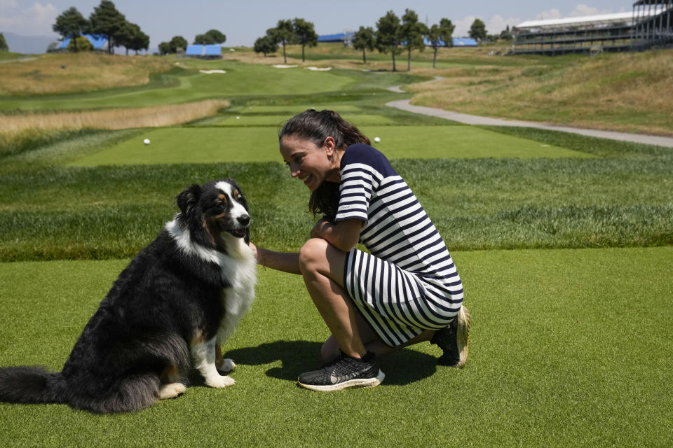 Lara Arias, a rare female golf course superintendent, caresses her Australian Shepard "Ryder" during an interview with the Associated Press, at the Marco Simone Club in Guidonia Montecelio, Italy, Tuesday, July 11, 2023. When Lara Arias started her job as course superintendent at the Marco Simone golf club outside Rome that will host the Ryder Cup from Sept. 29 to Oct.1 there was hardly any grass to manicure, no bunkers to rake and nary a green to shape, the entire course was practically one big pile of dirt amid a complete restyling. (AP Photo/Alessandra Tarantino)