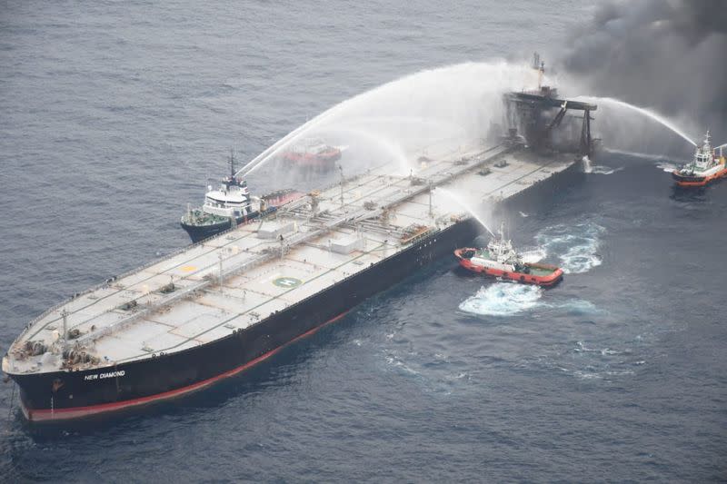 A Sri Lankan Navy boat sprays water on the New Diamond, a very large crude carrier (VLCC) chartered by Indian Oil Corp (IOC), that was carrying the equivalent of about 2 million barrels of oil, after a fire broke out off east coast of Sri Lanka