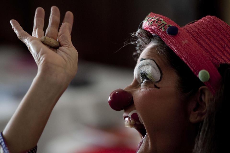 In a July 31, 2012 photo, Julie Varholdt, or "Lovely Buttons" the clown, performs an example while teaching a course on how clowns can entertain with everyday objects in a pinch at the third annual Clown Campin' in Ontario, Calif. The week-long event is held for clowns across the United States and Canada to learn, get inspired, and network. (AP Photo/Grant Hindsley)