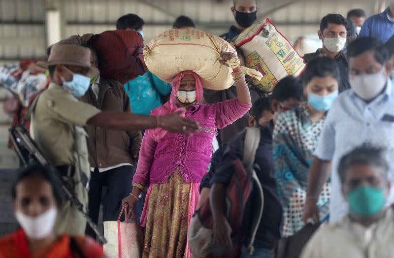 A policeman directs crowd at a railway station amidst the spread of the coronavirus disease (COVID-19) in Mumbai