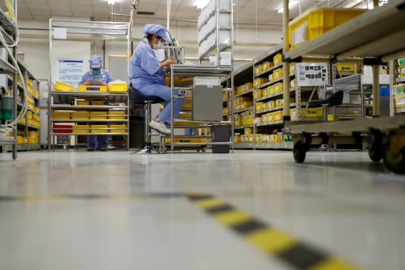 Employees wearing masks work at a factory of the component maker SMC during a government organised tour of its facility following the outbreak of the coronavirus disease (COVID-19), in Beijing