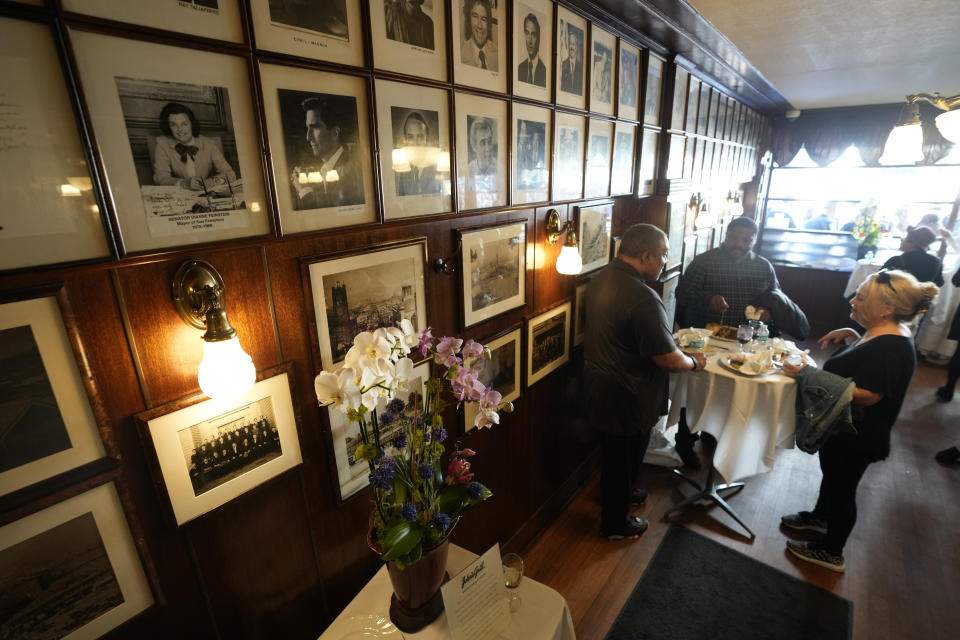 Flowers for the late Sen. Dianne Feinstein are seen below her photo hanging at John's Grill in San Francisco, Wednesday, Oct. 4, 2023. The restaurant, which celebrated its 115th anniversary Wednesday with a free lunch and appearances by San Francisco Mayor London Breed and other politicians, paid tribute to Sen. Feinstein who died last week. (AP Photo/Eric Risberg)