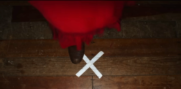 Pearl standing on an X on a stage