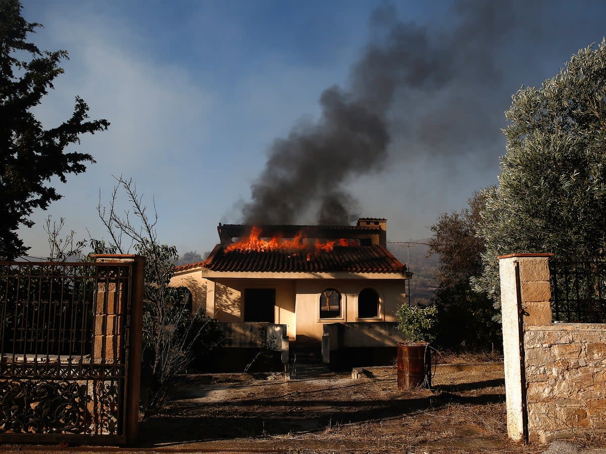 A house burns during a wildfire at Kalyvia area in Attica, Greece, 17 July 2023 (EPA)