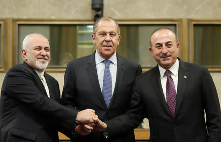 Russian Foreign Minister Sergei Lavrov, Turkish Foreign Minister Mevlut Cavusoglu and Iranian Foreign Minister Mohammad Javad Zarif shake hands as they attend a news conference after talks on forming a constitutional committee in Syria, at the United Nations in Geneva, Switzerland, December 18, 2018. REUTERS/Denis Balibouse