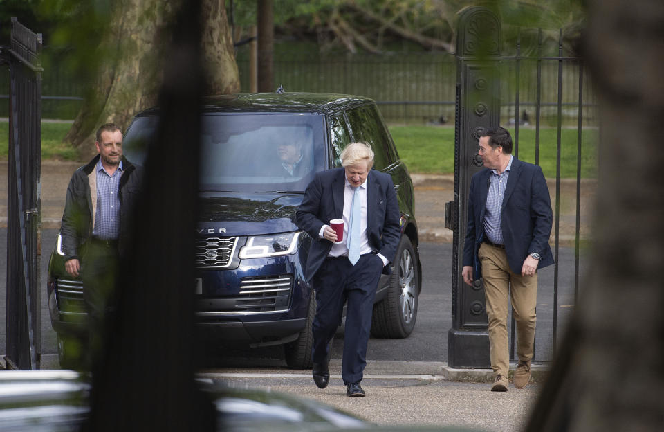 Britain's Prime Minister Boris Johnson, centre, takes a morning walk in St James' Park before returning to Downing Street in London, as the UK enters a seventh week of lockdown to help stop the spread of coronavirus, Tuesday May 5, 2020. After a long period of worldwide isolation, society is adapting to the new normal and the government is considering ways to relax current restrictions while still controlling the impact of the highly contagious COVID-19 coronavirus. (Stefan Rousseau / PA via AP)