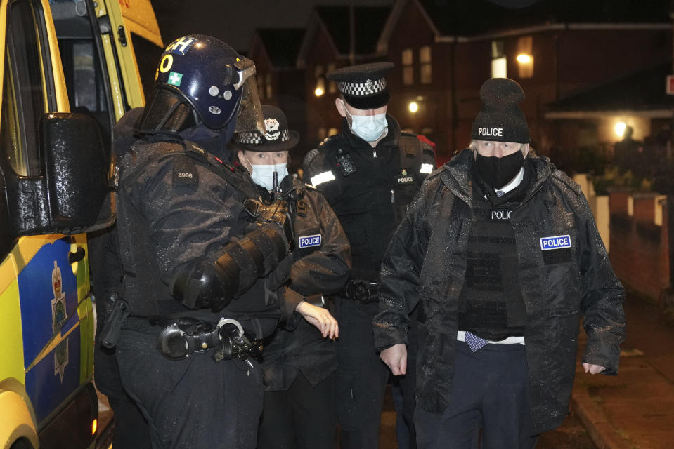 Britain's Prime Minister Boris Johnson, right, observes an early morning police raid on a home in Liverpool, England, Monday Dec, 6, 2021, ahead of the publication of the government's 10-year drug strategy. (Christopher Furlong/Pool via AP)