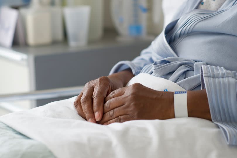 An elderly person's hands while they are sitting in bed in a care home